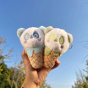 Close-up of cute panda ice cream cone plush pendants with metal keyrings against blue sky