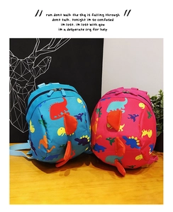Detail of cute dinosaur toddlers backpacks in blue and pink with 3D dorsal fins