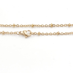 Close-up of golden stainless steel bead chain necklace with secure lobster clasp detail