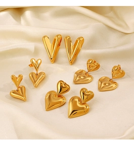 Detailed macro shot of 18K gold plated heart earrings on elegant beige silk fabric