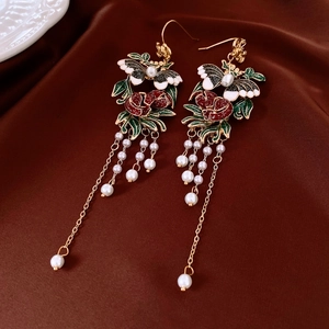 Detail of vintage gold earrings with butterfly flower drops and pearl tassels