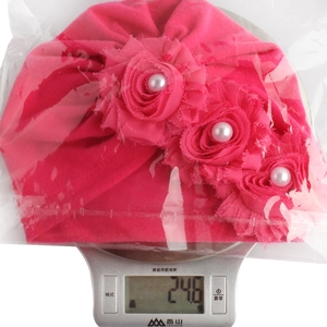 Rosa Baby-Blumen-Turban auf einer Waage mit einem Gewicht von 24,6 g für die Produktdetails