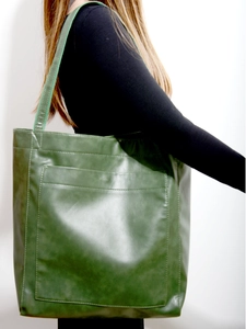 Vue latérale du grand sac cabas vert en cuir ciré avec poche porté par un mannequin