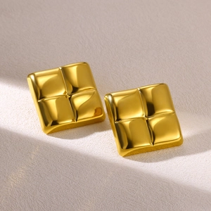 Macro detail of square geometric 18K gold plated earrings with quilted texture