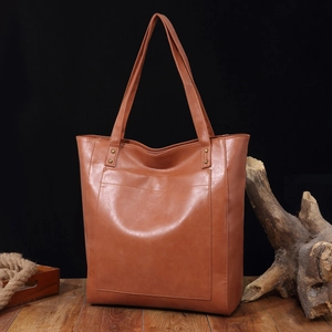Détail du sac cabas vintage en cuir marron avec poche avant et texture de haute qualité