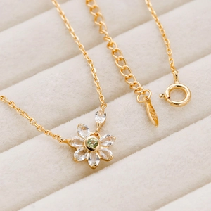 Macro shot of S925 silver 14K gold floral necklace with green zircon gemstone and details