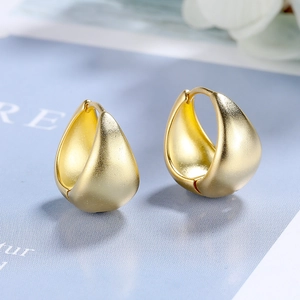 Close-up of matte gold waterdrop hoop earrings with elegant brushed metal texture