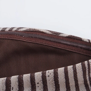Detailaufnahme von braunem Zebra-Stoff mit dunklem Netzfutter und Lederbesatz am Kleid