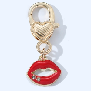 Detail of a red enamel lip pendant with small rhinestones on a gold lobster clasp keychain