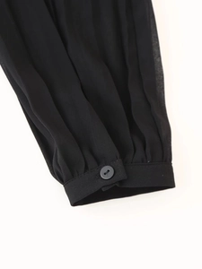 Detail of long sleeve cuff with button and pleated chiffon fabric in black color