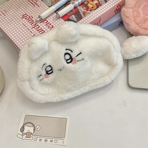Detail of cute white plush stationery bag with embroidered cartoon eyes and fluffy ears