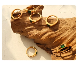 Detailed macro of gold-plated titanium steel ring with an emerald green square zircon stone