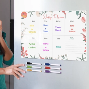 Magnetic acrylic weekly planner on fridge with six colorful markers and floral decor