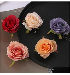 Detailed view of assorted artificial rose hair clips in red, pink and purple tones