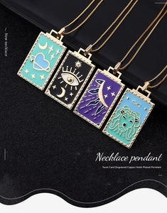Macro detail of tarot pendants showing gold-plated copper and fine enamel craftsmanship