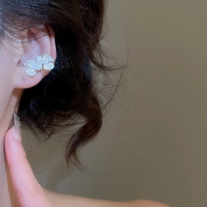 Macro shot of silver zircon flower ear cuff showing the delicate petal texture