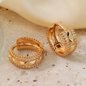 Elegant gold-tone hoop earrings with micro-set zircons on a marble base and silk background