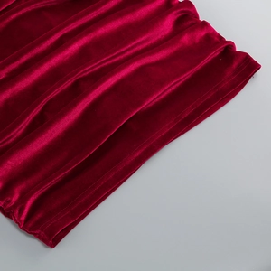 Détail du tissu en velours rouge montrant la texture lisse et brillante de la robe