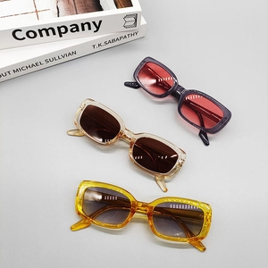 Close-up of retro oval sunglasses in burgundy, amber tea, and bright yellow colors