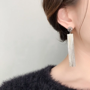 Close-up of elegant silver tassel earrings featuring delicate chain fringe and woven knot