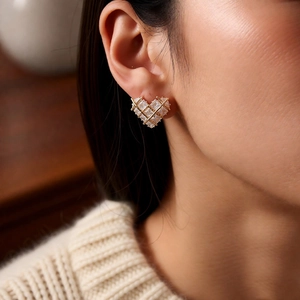 Close-up of 18k gold plated heart stud earrings with cubic zirconia on model