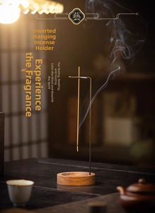 Close-up of inverted incense burner with wood base and rising smoke in zen setting