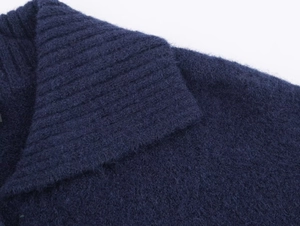 Close-up of navy blue knit cardigan showing soft brushed texture and ribbed collar detail