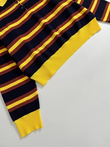 Detail of striped knit Polo shirt with yellow ribbed cuffs and navy yellow brown stripes