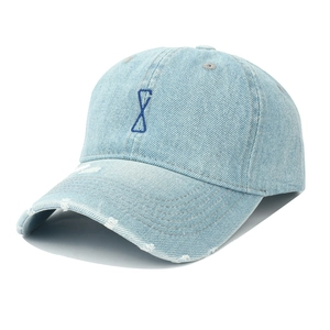Detail of light blue denim baseball cap showing embroidery and distressed brim texture
