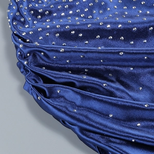 Macro detail of royal blue fabric with sparkling silver rhinestone accents and elegant draping