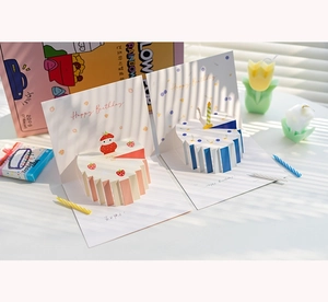Dettaglio di biglietti d'auguri 3D creativi con torte di carta rosa e blu
