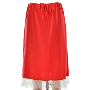 Détail d'une jupe midi rouge avec taille nouée et élégante bordure en dentelle blanche