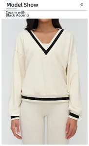 Detail of V-neckline with black and white contrast ribbed trim on apricot sports sweatshirt