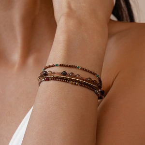 Detail van bohemien meerlaagse armband met bruine glazen kralen en gouden accenten