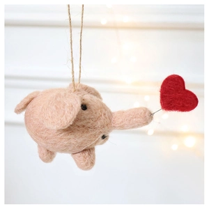 Detail of a handmade pink wool felt elephant ornament with a red heart and jute rope