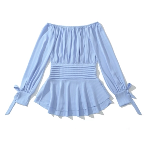 Détail du tissu plissé bleu clair du haut épaules dénudées avec taille smockée et volants