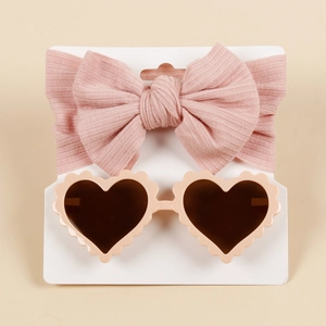 Detailed set of pink knitted bow headband and heart-shaped sunglasses for baby girls