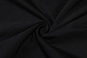 Macro shot of high-quality black knitted textile fabric with soft spiral texture and elegant sheen
