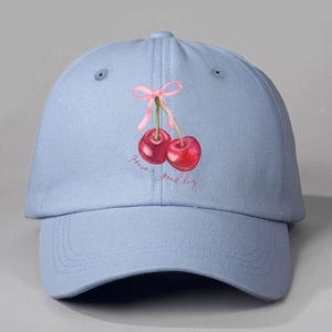 Detailed close-up of light blue cotton baseball cap with cherry and bow embroidery