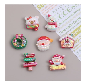 Macro shot of 7 iridescent Christmas resin charms including gingerbread house and snowman