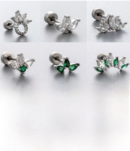Macro detail of silver titanium steel screw back stud earrings with green zircon crowns