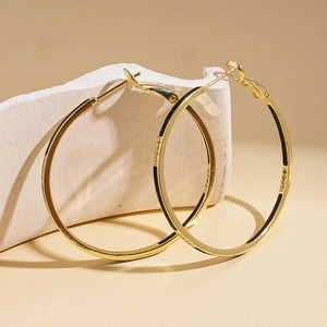 Vue détaillée des boucles d'oreilles créoles géométriques plaquées or 14 carats sur pierre