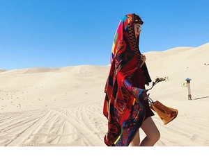 Close-up of lightweight colorful silk shawl with ethnic paisley patterns in desert setting