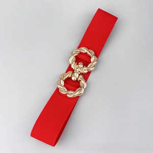 Detail of red elastic waist belt featuring a decorative gold metal twist buckle
