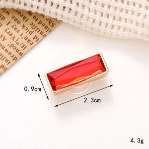 Macro shot of rectangular red rhinestone charm in gold setting for DIY accessories