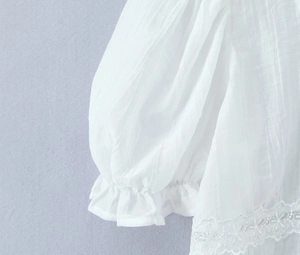 Détails des manches bouffantes blanches avec dentelle et tissu texturé vertical