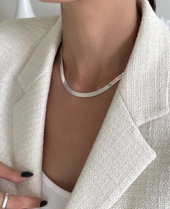 Detail of 4mm silver herringbone snake chain showing high-polish texture on model