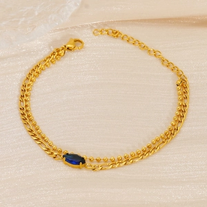 Double-layer gold figaro and bead chain bracelet with a blue marquise-cut gemstone charm