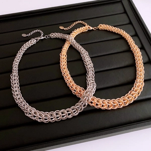 Vue détaillée de colliers à maillons entrelacés en argent et or avec fermoir mousqueton