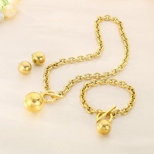Close-up of golden chunky chain jewelry set with OT toggle clasp and spherical pendants